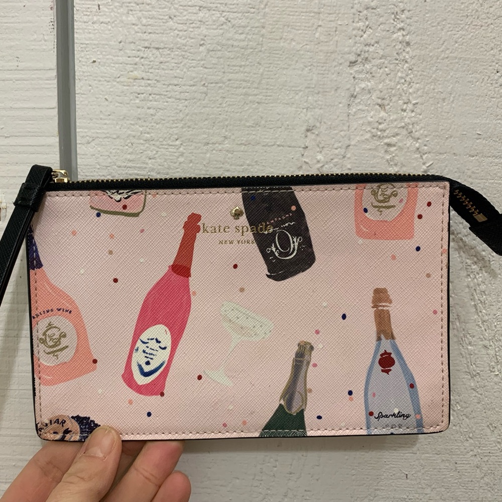 Kate Spade Shore Street Tinie wristlet with a champagne bottles print.
